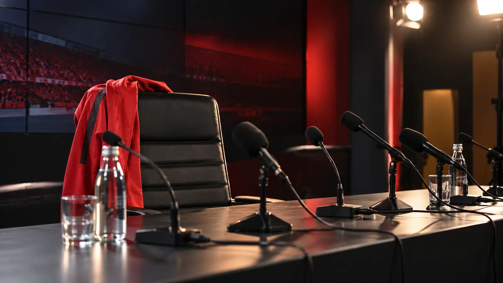Sala de prensa vacía tras una destitución Sala de prensa vacía con micrófonos y una chaqueta roja sobre la silla del entrenador, como cierre de la etapa de Vicens en Braga